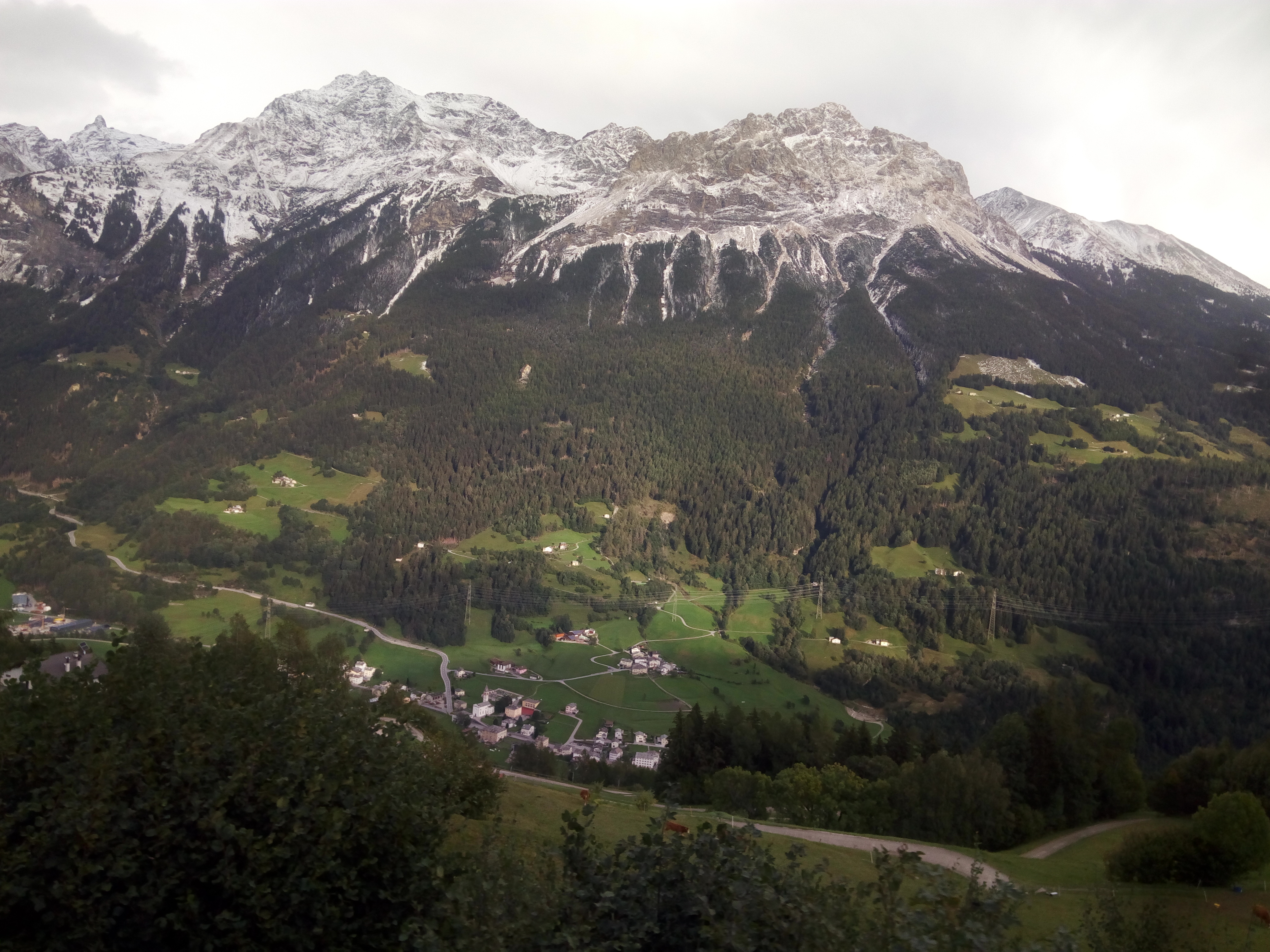 Puschlav nach Berninagebiet und vor Poschiavo aus der Rhätischen Bahn heraus fotografiert. Deutlich zu erkennen: Unten noch alles grün, oben Schnee.